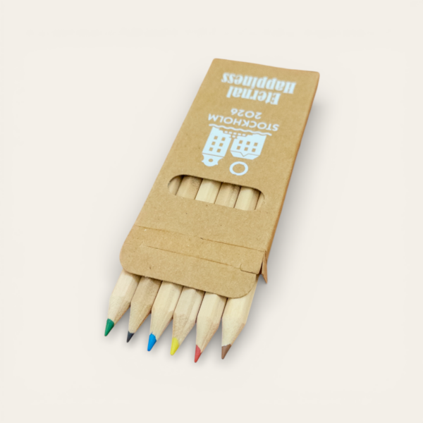 Set de 6 lápices de colores presentado en una caja personalizada con el logo oficial de la Asamblea Internacional 2026 "Felices para siempre"
